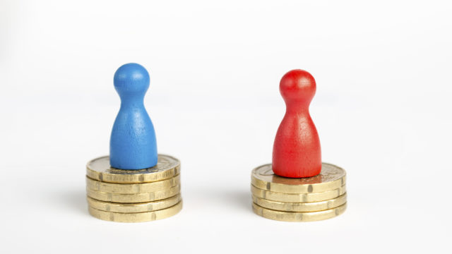 Wage gap concept with blue figure symbolizing men and red pawn women