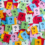 Too Many Questions. Pile of colorful paper notes with question marks. Closeup.