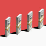 6 bundles of US $100 bills standing vertically on edge of white shelf, red background